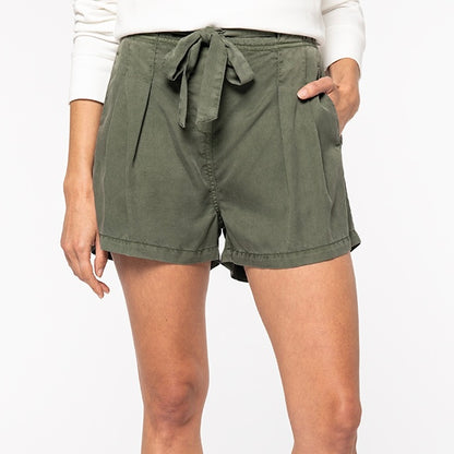 Image shows a woman wearing our khaki women's Tencel string bow shorts against a neutral background.