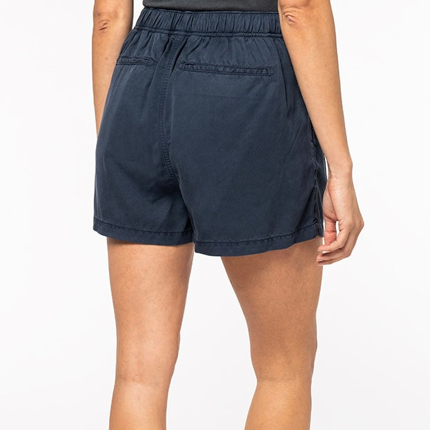 Image shows a woman from the back wearing our women's navy tencel string bow shorts against a neutral background.