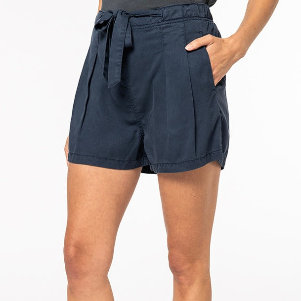 Image shows a woman wearing our Navy women's Tencel string bow shorts against a neutral background.